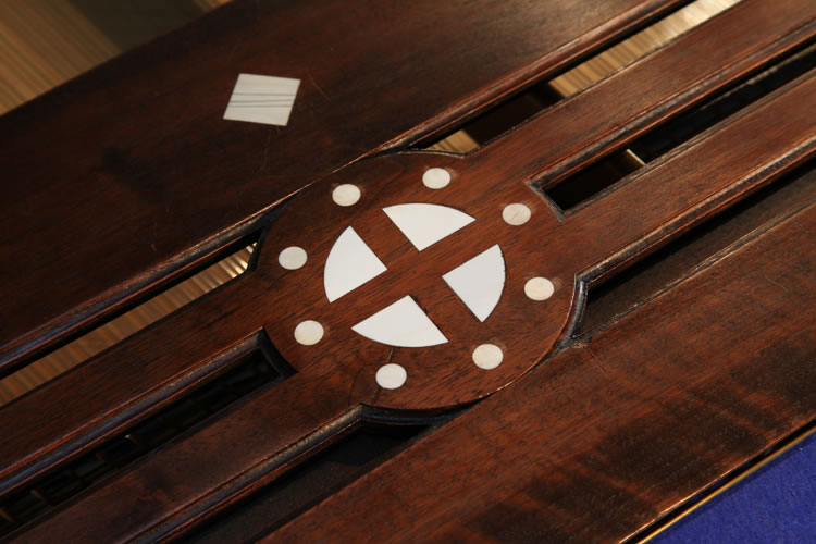 In the centre of the music desk is an inlaid circle with central cross.  Viewed as a Norse symbol, this suggests the sun wheel, one of the oldest spiritual symbols of the Germanic people. The central cross seperates the circle into four pieces, just like the seasons in a year. It is representative of life, fertility and peace.