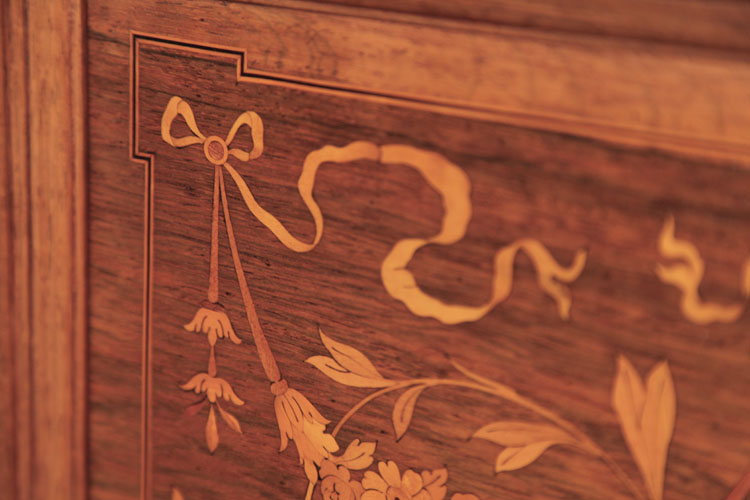 Detail of inlay featuring a bow with hanging bellfowers and fluttering ribbons