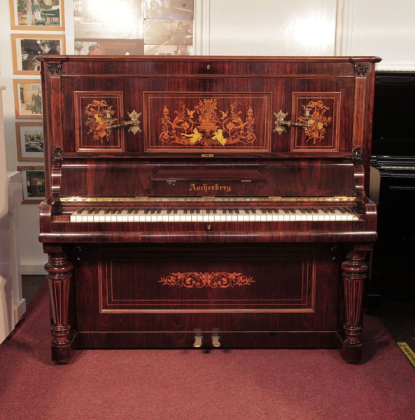 Restored, 1890, Ascherburg upright piano with a rosewood case and turned, faceted legs. Cabinet features panels inlaid with a Neoclassical design in a variety of woods.