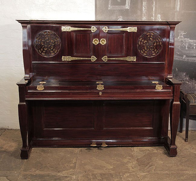 An 1897, Arts and Crafts style, Bechstein upright piano with a mahogany case, fretwork panels and ornate brass hinges in a stylised floral design