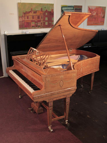 Golden Age of Pianos. Rebuilt, 1911, Bluthner grand piano with a quarter cut, satinwood case with boxwood stringing inlay. Entire cabinet inlaid with swagged bellflowers, secured with bows 