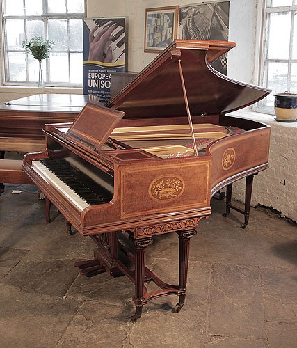 Golden age of pianos. Reconditioned, 1894, Broadwood grand piano with a fiddleback mahogany case and tapered fluted legs attached with a cross stretcher. Cabinet inlaid with oval panels featuring muical instruments and foliage and flowers and satinwood crossbanding and stringing accents