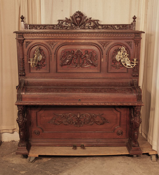Neoclassical style, Francke upright piano for sale with an ornately carved, oak case and griffin legs. Cabinet features carved angels, lions heads, acanthus and openwork arcading.