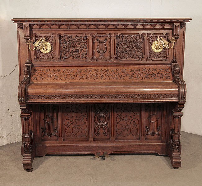 Renaissance style, Gebruder Knake upright piano for sale with an ornately carved, oak case. Cabinet features front panels carved with arabesque style, flowers, foliage and a central lyre.
