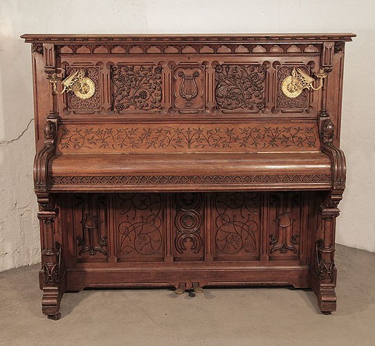The Golden Age of Pianos. Renaissance style, Gebruder Knake upright piano for sale with an ornately carved, oak case. Entire cabinet carved with arabesque style, flowers and foliage in high relief. Seated dragons recline at the base of the Classical columnar, piano legs. Gothic tracery and arches also feature strongly the cabinet architecture. 