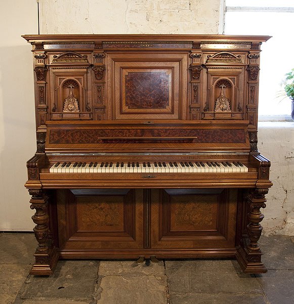 A German upright piano with a Neoclassical style walnut case and cup and cover legs