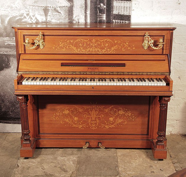An 1893, Pleyel upright piano with a satinwood case, brass candlesicks and fluted, column legs