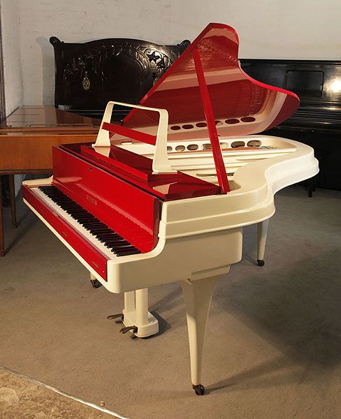 A 1959, Rippen grand piano with a contrasting cherry polyester and painted aluminium case. This Rippen piano has a beautiful slimline outline and minimal openwork music desk. Piano features a reverse crown soundboard and tapered legs. Piano has an eighty-eight note keyboard and a two-pedal piano lyre.