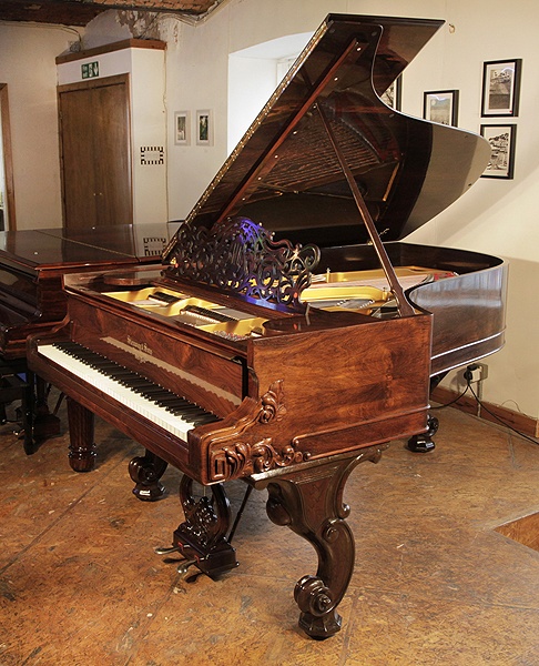 A rebuilt, 1877, Steinway Style 1 grand piano for sale with a french polishedrosewood case. Cabinet features carved, Rococo styling and scroll foot legs. Piano has an eighty-five note keyboard and a two-pedal lyre. 